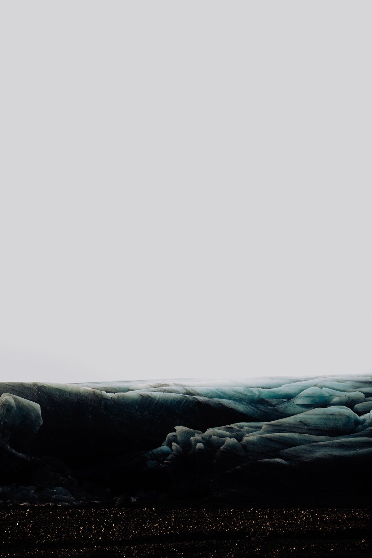 A stunning fine art print titled 'Glacial 819' from Addison Jones Studio, showcasing the serene landscape of a glacier under a grey sky. This artistic piece captures a moody ambiance, perfect for enriching any art collection.