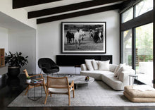 Load image into Gallery viewer, A modern living room featuring a large framed black and white photo of horses, beautifully integrating Horse Art into the contemporary interior design.
