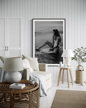 Load image into Gallery viewer, A cozy and bright room decorated with &#39;Riding Tide&#39;, a captivating photograph of a woman on a surfboard, creating a tranquil and beach-inspired atmosphere.
